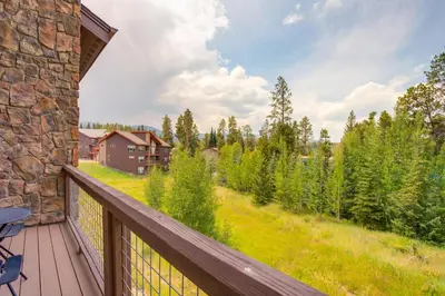 a deck with a view of a house and trees at 2 Mi to Fraser River Trail Townhome with Hot Tub! in Fraser