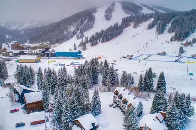 a village covered in snow with a ski slope at Ski-InandSki-Out Gemini Lift Access! Home with Hot Tub in Winter Park