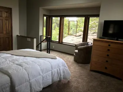 a bedroom with a bed and a television and a chair at Rancho la Chula - Gambling Golf Hiking Hot Tub! in Black Hawk