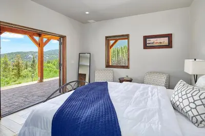 a bedroom with a large bed and a large window at Rancho la Chula - Gambling Golf Hiking Hot Tub! in Black Hawk