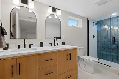 a bathroom with a sink and a toilet and a mirror at Denver 5BR Hot Tub, Pool Table, Ping Pong! in Denver