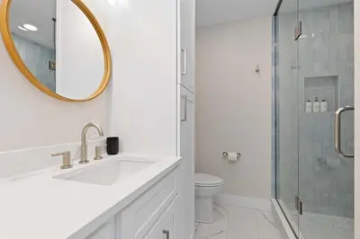 a white bathroom with a sink and a shower at Denver 5BR Hot Tub, Pool Table, Ping Pong! in Denver
