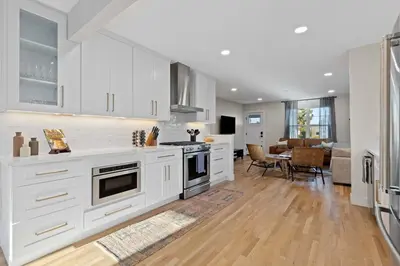 a kitchen with white cabinets and a dining room at Denver 5BR Hot Tub, Pool Table, Ping Pong! in Denver