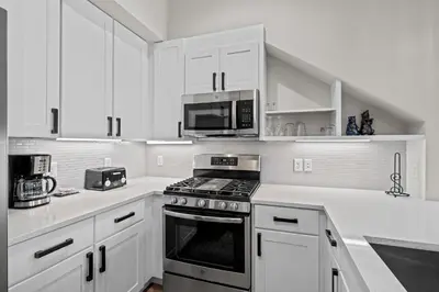 a white kitchen with a stove and a microwave at 78311 US HWY 40 Unit 6 in Winter Park