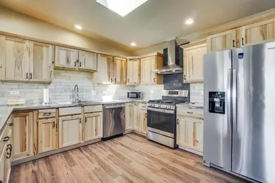a kitchen with wooden cabinets and a stainless steel refrigerator at Yak Ranch with Mountain Views, Near Wellington!