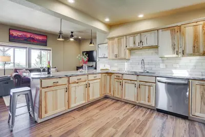 a large kitchen with wooden cabinets and appliances at Yak Ranch with Mountain Views, Near Wellington!