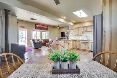 a kitchen and living room with a table with flowers on it at Yak Ranch with Mountain Views, Near Wellington!