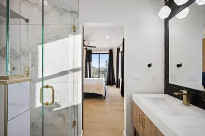 a bathroom with a shower and a sink and a bedroom at Modern Mtn Escape! Hot Tub Fireplace Views! in Bailey