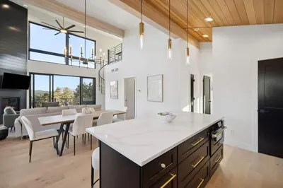 a kitchen with a large island and a dining room at Modern Mtn Escape! Hot Tub Fireplace Views! in Bailey