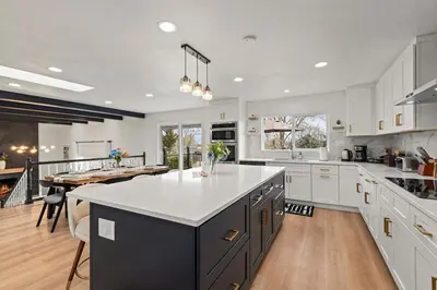 a large kitchen with white cabinets and a large island at Lake Arbor Family Retreat with Backyard Oasis in Arvada