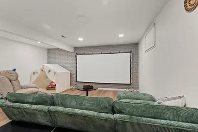 a living room with a couch and a projection screen at Lake Arbor Family Retreat with Backyard Oasis in Arvada