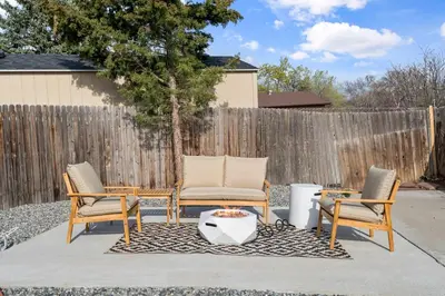a patio with three chairs and a table and a fence at Lake Arbor Family Retreat with Backyard Oasis in Arvada