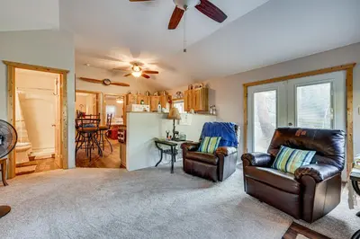 a living room with two leather chairs and a kitchen at Hike, Fish and Relax Cabin 4 Mi to Lake Estes! in Drake