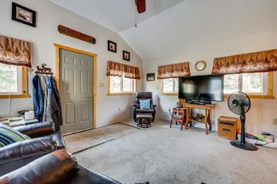 a living room with a couch and a television at Hike, Fish and Relax Cabin 4 Mi to Lake Estes! in Drake
