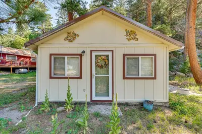 a small white shed with a door and windows at Hike, Fish and Relax Cabin 4 Mi to Lake Estes! in Drake