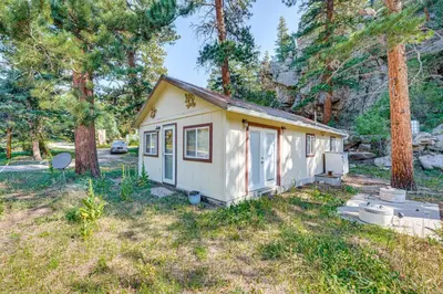 a tiny house in a yard with trees at Hike, Fish and Relax Cabin 4 Mi to Lake Estes! in Drake