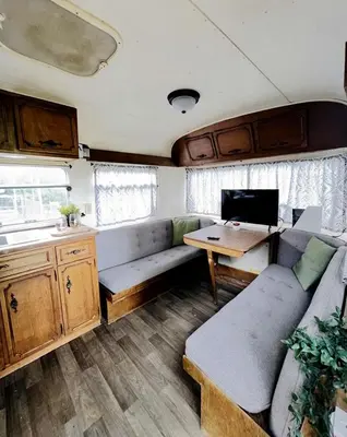 a living room with a couch and a desk in an rv at Cute Vintage Caravan for a Peaceful Escape in Niwot, Colorado in Niwot
