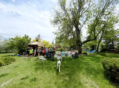 a group of people and a dog standing in the grass at Cute Vintage Caravan for a Peaceful Escape in Niwot, Colorado in Niwot