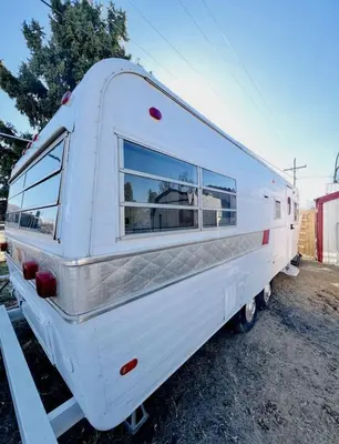 a white trailer is parked in a lot at Cute Vintage Caravan for a Peaceful Escape in Niwot, Colorado in Niwot