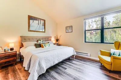 a bedroom with a bed and a yellow chair at 2 Mi to Winter Park Slopes Mtn-View Condo! in Winter Park