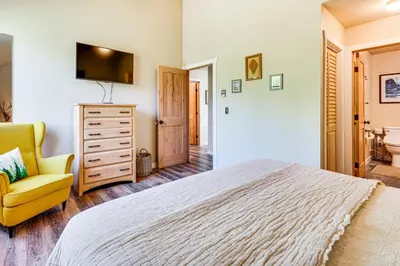 a bedroom with a bed and a yellow chair at 2 Mi to Winter Park Slopes Mtn-View Condo! in Winter Park