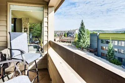 a balcony with chairs and a view of a city at 2 Mi to Winter Park Slopes Mtn-View Condo! in Winter Park