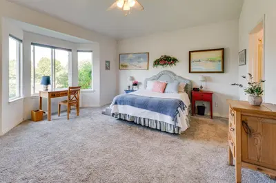 a bedroom with a bed and a desk and windows at Pet-Friendly Longmont Home with McIntosh Lake Access in Longmont