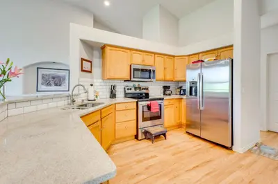 a kitchen with wooden cabinets and a stainless steel refrigerator at Pet-Friendly Longmont Home with McIntosh Lake Access in Longmont