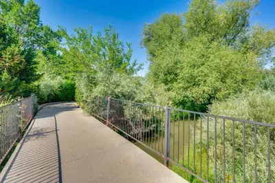 a walkway next to a fence with trees at Pet-Friendly Longmont Home with McIntosh Lake Access in Longmont