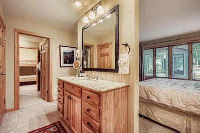 a bathroom with a sink and a mirror and a bed at 1702 The Willows condo in Keystone