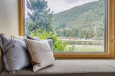 a window with pillows sitting on a couch looking out at 1702 The Willows condo in Keystone