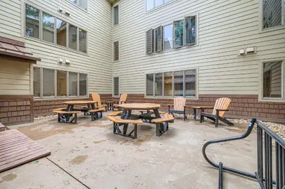 a patio with wooden tables and chairs next to a building at 1702 The Willows condo in Keystone