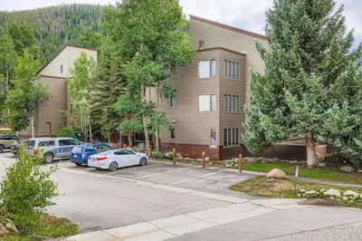 a house with cars parked in a parking lot at 1702 The Willows condo in Keystone