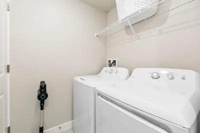 a white laundry room with a washer and dryer at Northfield Old Town Flat with Attached Garage and EV in Fort Collins