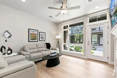 a living room with a couch and a ceiling fan at Northfield Old Town Flat with Attached Garage and EV in Fort Collins
