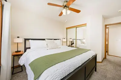a bedroom with a large bed with a ceiling fan at Shady Grove with 4 King Beds, Dog Run and Outdoor Fun in Loveland