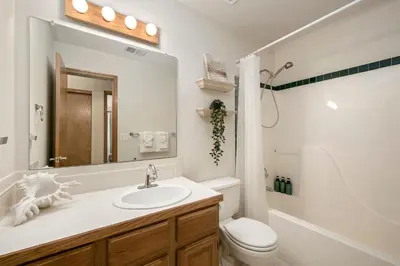 a bathroom with a sink and a toilet and a mirror at Shady Grove with 4 King Beds, Dog Run and Outdoor Fun in Loveland