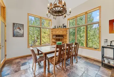 a dining room with a table and chairs and windows at Modern Mountain Stay Hot Tub Fire Pit and Views in Silverthorne