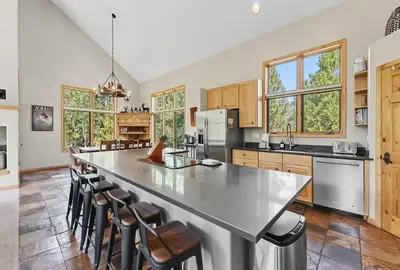 a kitchen with a large island with bar stools at Modern Mountain Stay Hot Tub Fire Pit and Views in Silverthorne