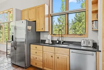 a kitchen with a stainless steel refrigerator and windows at Modern Mountain Stay Hot Tub Fire Pit and Views in Silverthorne