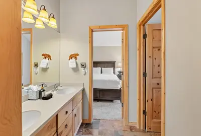 a bathroom with a sink and a mirror and a bed at Modern Mountain Stay Hot Tub Fire Pit and Views in Silverthorne
