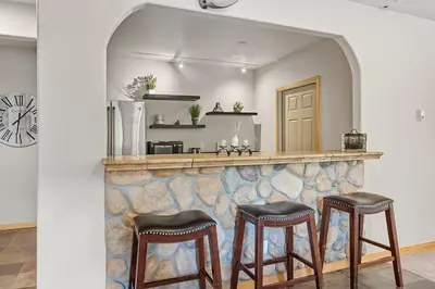 a bar with two stools in front of a wall at Modern Mountain Stay Hot Tub Fire Pit and Views in Silverthorne