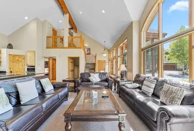 a living room with leather furniture and large windows at Modern Mountain Stay Hot Tub Fire Pit and Views in Silverthorne