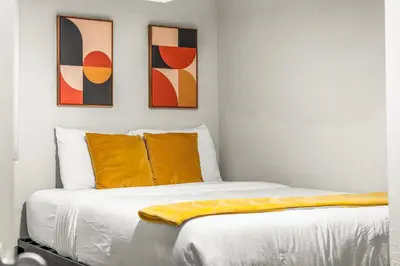 a bedroom with a bed with three paintings on the wall at Modern 4BR Family Friendly Retreat with Hot tub in Arvada
