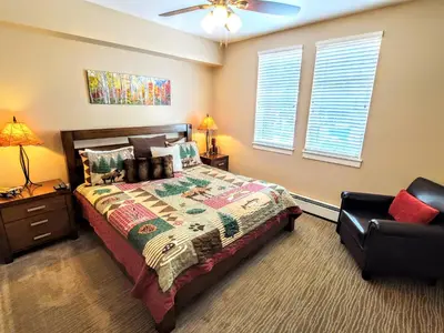a bedroom with a bed and a chair at Amenities Deck Level, Walk to Gondola WP Resort in Winter Park