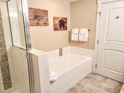 a white bathroom with a tub and a shower at Amenities Deck Level, Walk to Gondola WP Resort in Winter Park