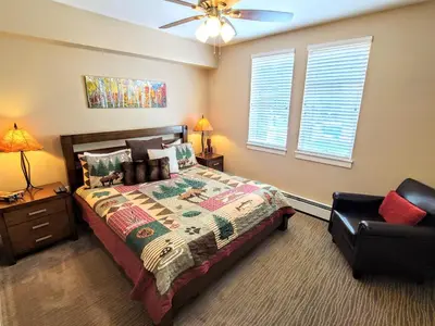 a bedroom with a bed and a chair at Amenities Deck Level, Walk to Gondola WP Resort in Winter Park