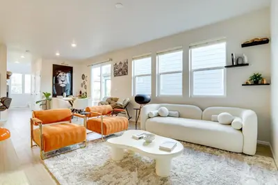a living room with a white couch and orange chairs at Less Than 2 Mi to Gaylord Rockies Remote-Work Hub with Gym! in Aurora