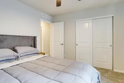 a bedroom with a large bed and white walls at Less Than 2 Mi to Gaylord Rockies Remote-Work Hub with Gym! in Aurora