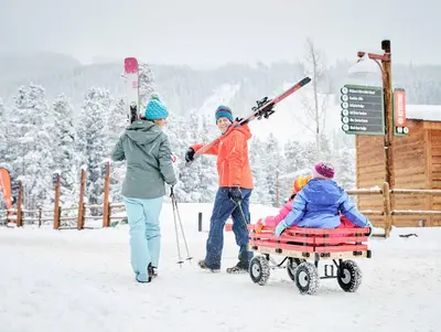 a group of people pulling a person in a sled in the snow at Studio in Lakeside Village, Updated Kitchen & Bath apts in Keystone